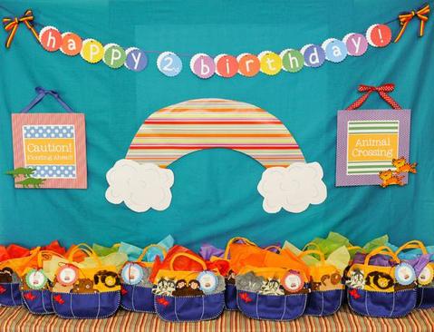 Noah’s ark-themed 2nd birthday party with rainbow decor and ark-shaped goodie bags.