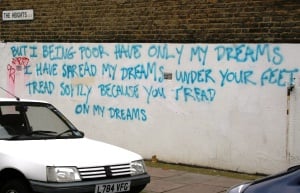 Image shows graffiti in large blue letters quoting in the end of