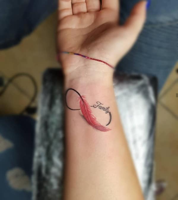 pink feather family tattoo on wrist
