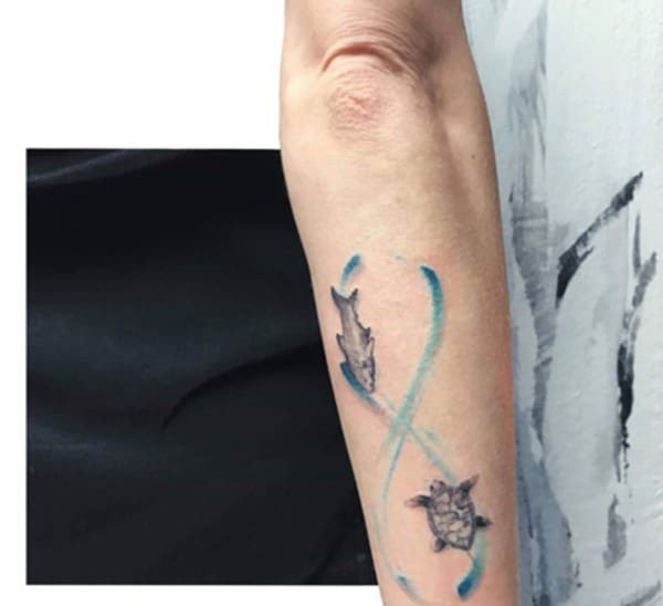 fish and turtle inside blue sign design tattoo on arm