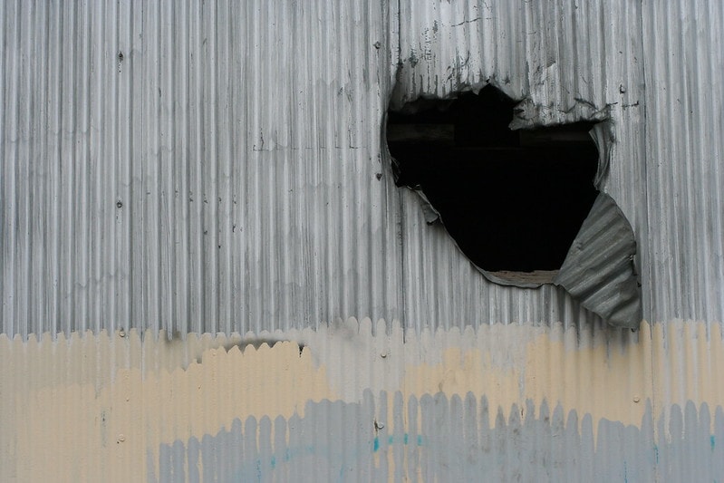 hole in corrugated metal wall_Lars Hammar_Flickr