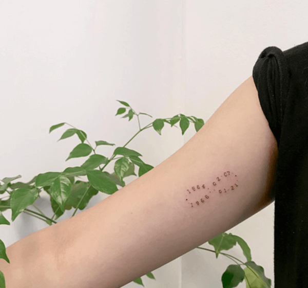 infinity with dates tattoo on arm