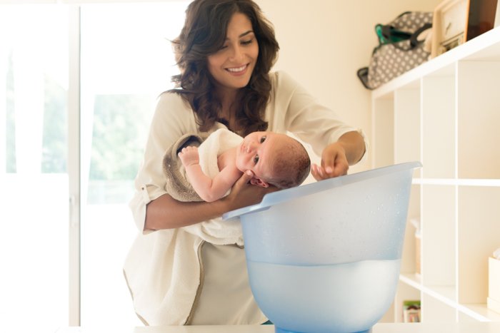 Cute newborn photo idea of the mother bathing the baby