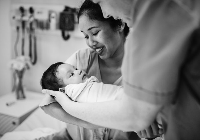 Cute newborn portrait of the mother holding the baby fore the first time