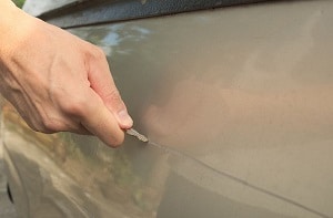 person scratching a car