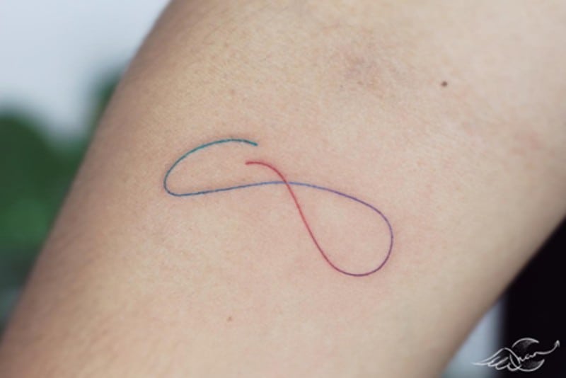 rainbow thread sign tattoo on arm